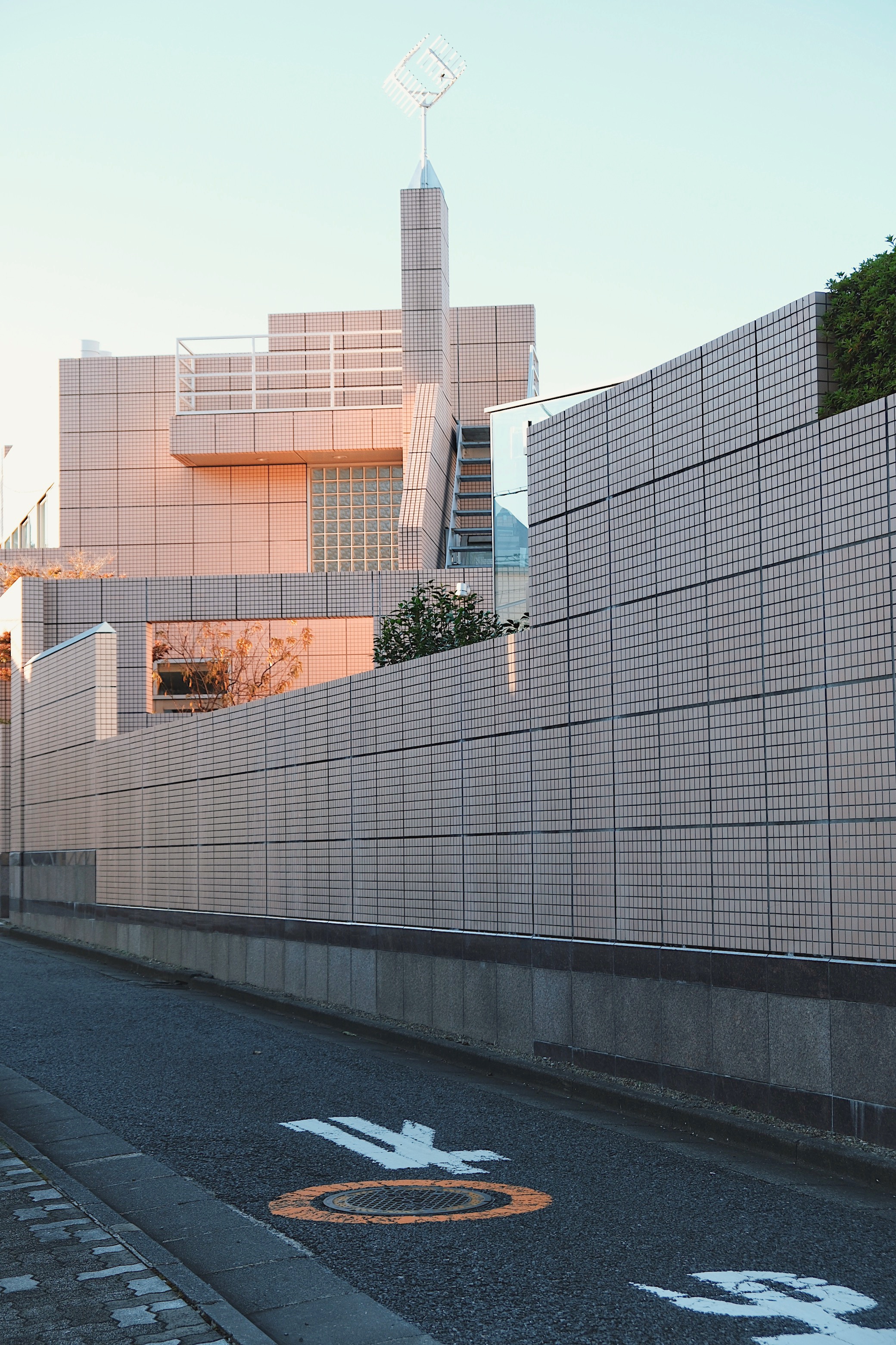 A contemporary minimalist building in Daikanyama, Tokyo, with tiled facades and soft sunset hues, reflecting the neighborhood’s upscale aesthetic.