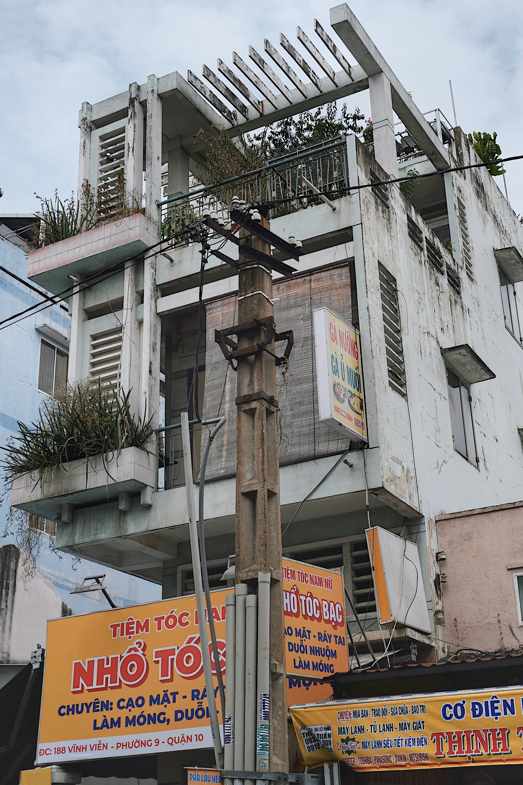 A collection of mid-century modernist buildings in Ho Chi Minh City, with cantilevered balconies and sun-shading pergolas.