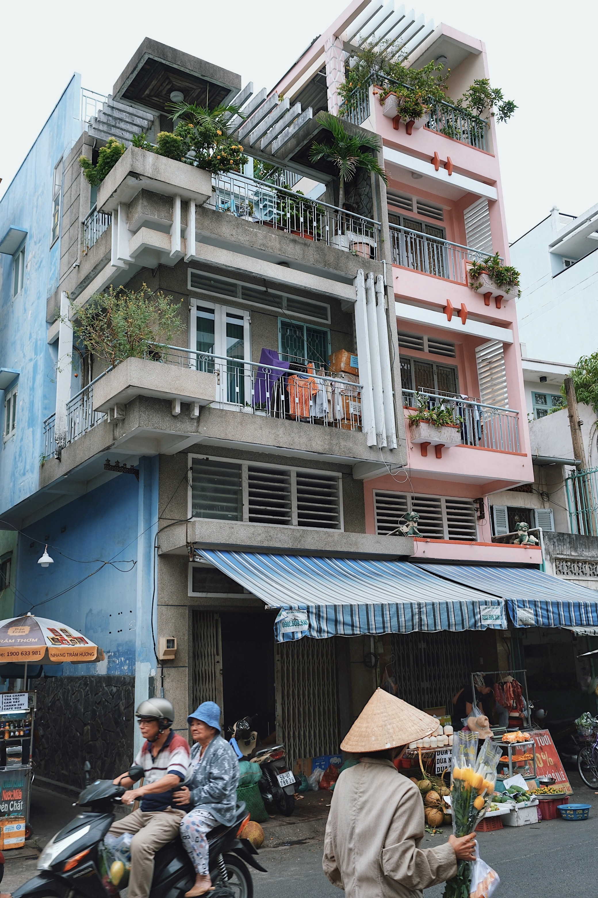 Colorful modernist housing block in District 9, Ho Chi Minh City, with rhythmic concrete details, deep balconies, and vernacular reinterpretations of postwar modernism