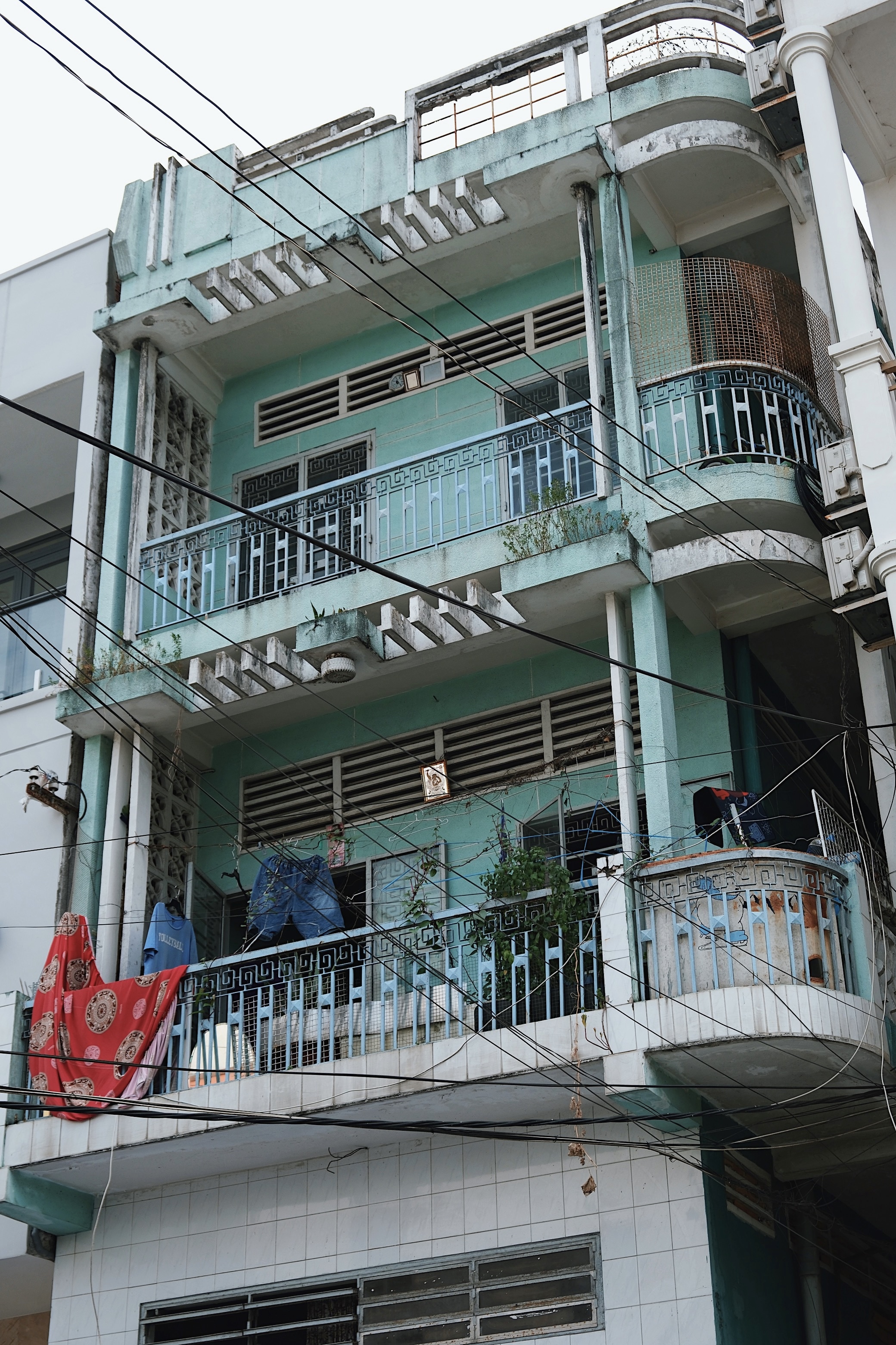 Tropical modernist architecture in Can Tho, Vietnam, featuring open-air terraces, decorative facades, and functionalist brise-soleil.
