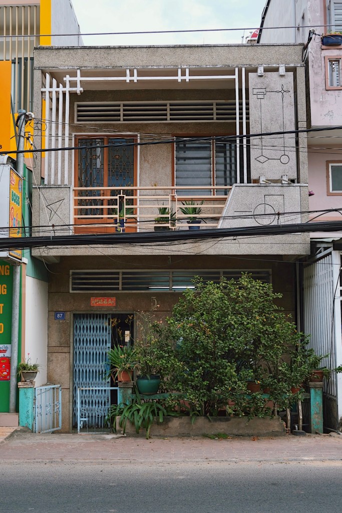 A shophouse in Chau Doc adorned with geometric decorations and Vietnamese modernist features, including double-wall balconies and concrete brise soleils, blending functionality with cultural design.