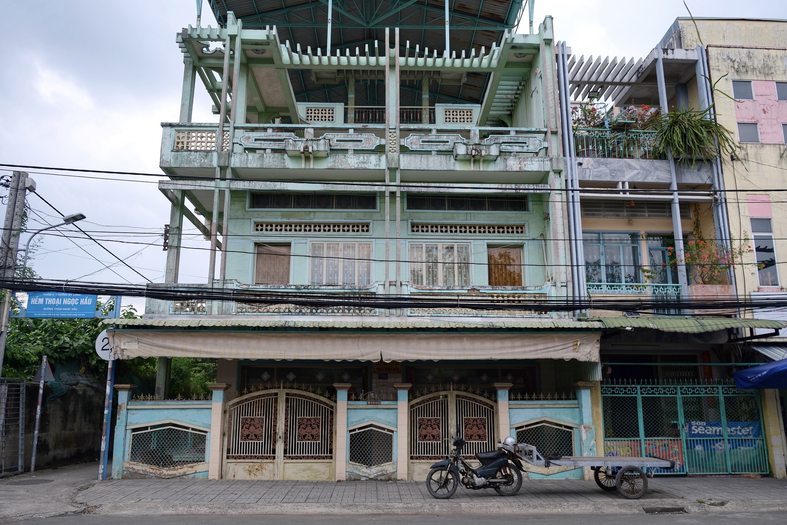 South Vietnamese modernist buildings in Long Xuyen, featuring angular balconies, sun-shading overhangs, and concrete louvers.