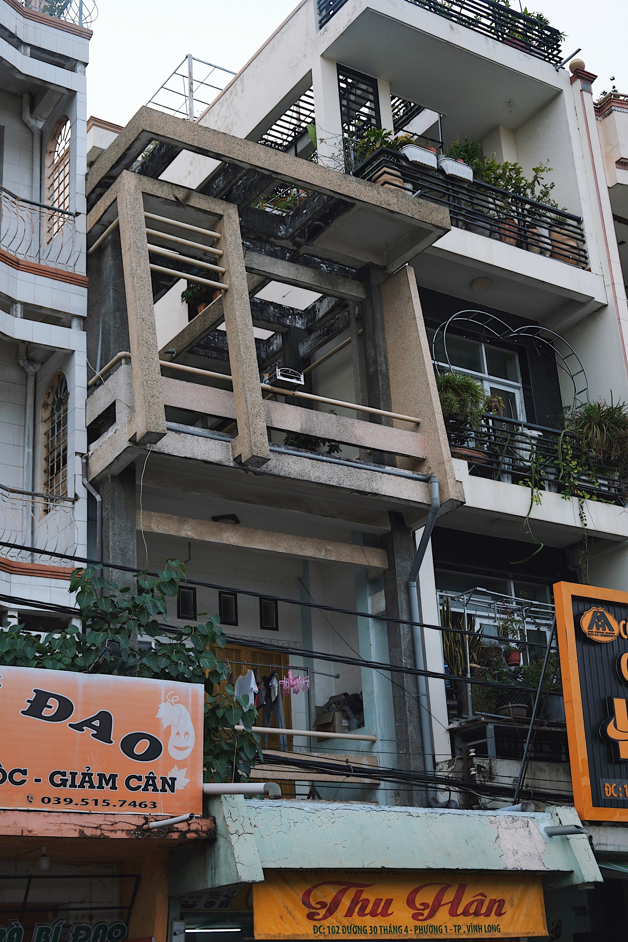 Tropical adaptation of modernism in Vinh Long, featuring perforated concrete screens and open-air corridors for natural ventilation.
