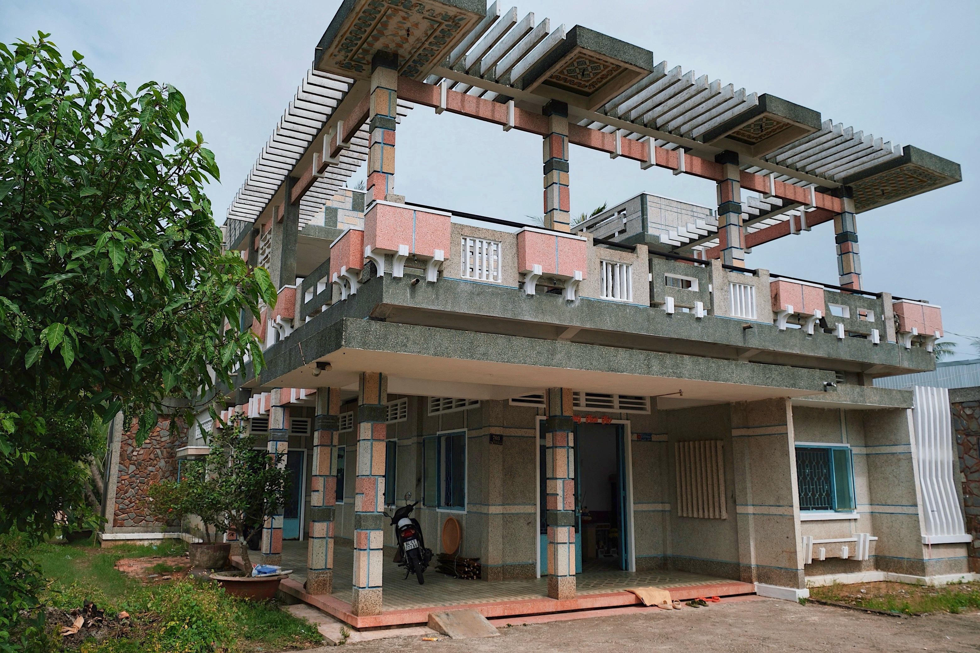 A pink modernist villa in Vinh Long (Mekong Delta), showcasing intricate architectural details. The most complex modernist building encountered in Vietnam.