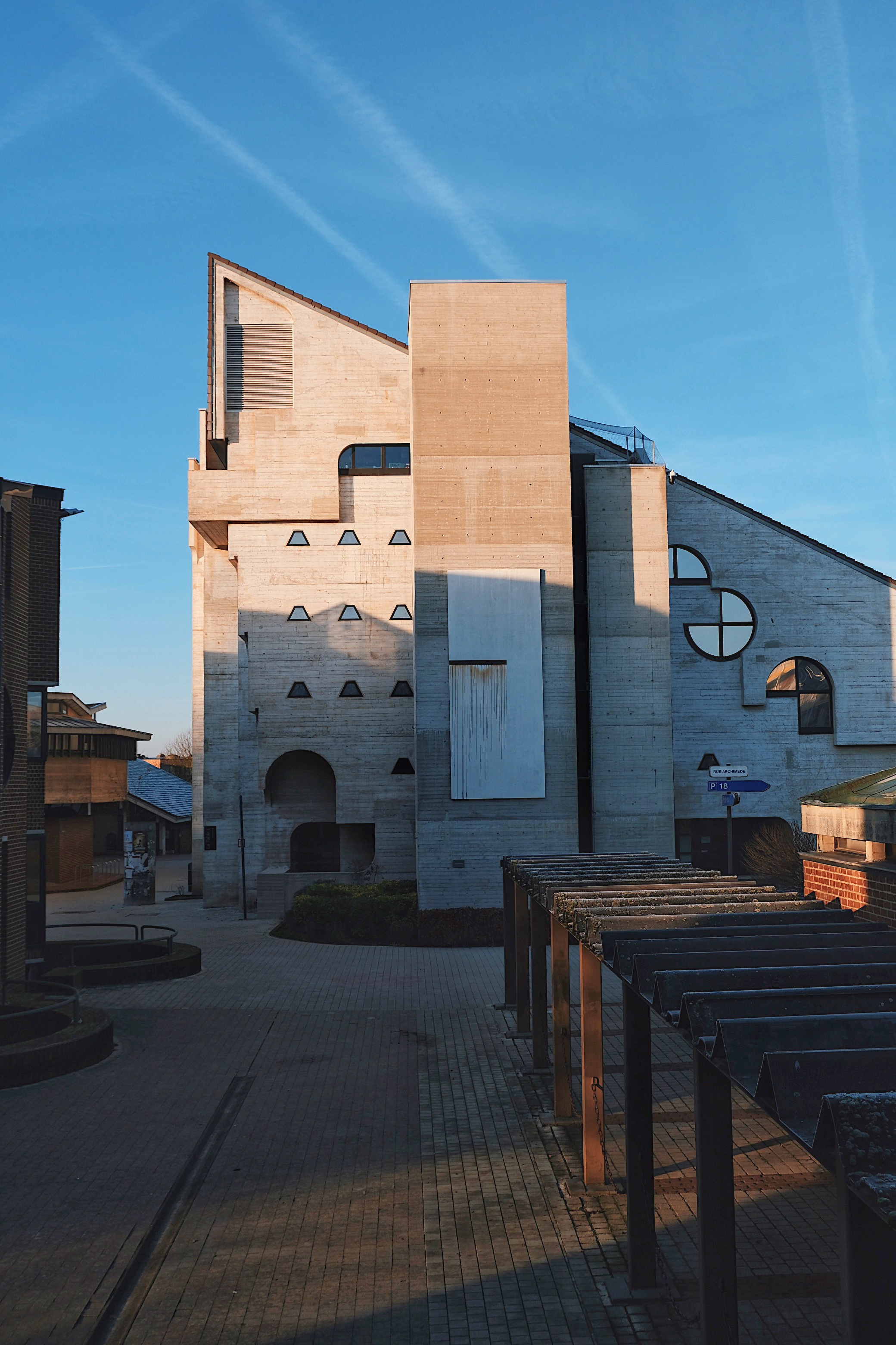The back of the Bibliothèque des Sciences in Louvain-La-Neuve, a brutalist masterpiece by André Jacqmain with angular concrete facades and striking architectural lines.