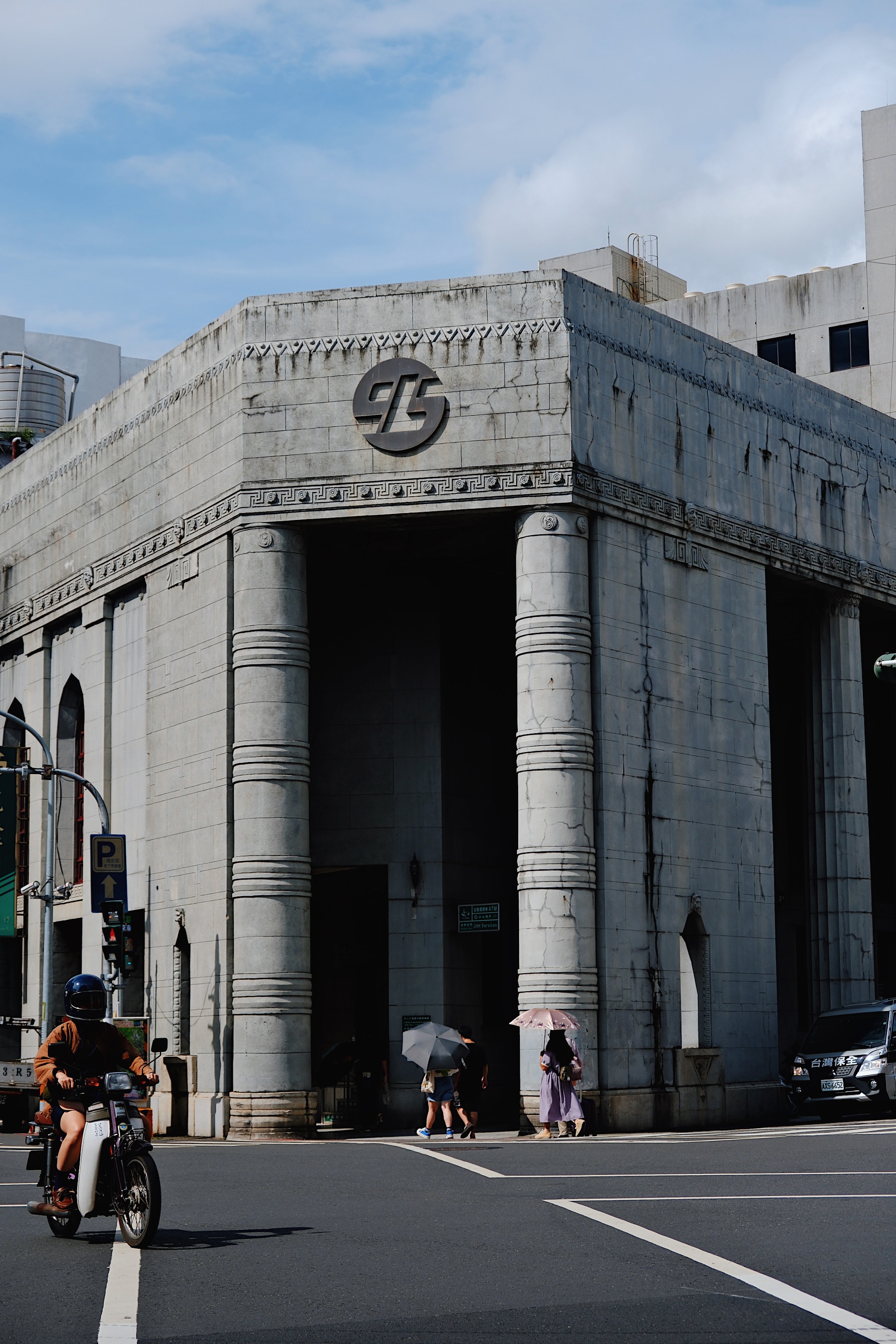 A Brutalist-style bank in Tainan, Taiwan, with imposing concrete pillars and intricate geometric detailing, reflecting 1970s modernist influences.
