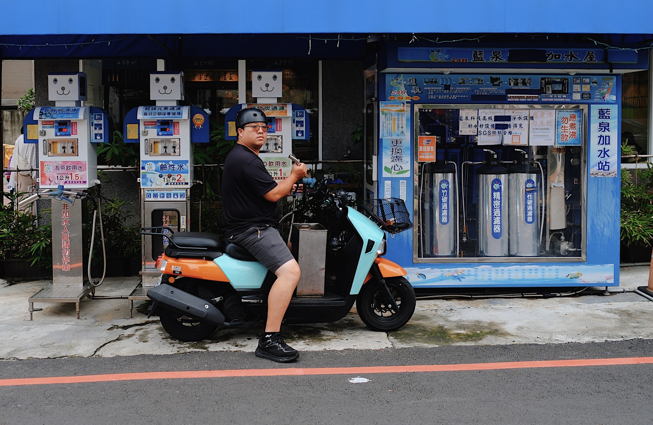 A playful gas station in Tainan, Taiwan, featuring blue and white fuel dispensers decorated with smiling cartoon faces, adding a whimsical touch to urban infrastructure.