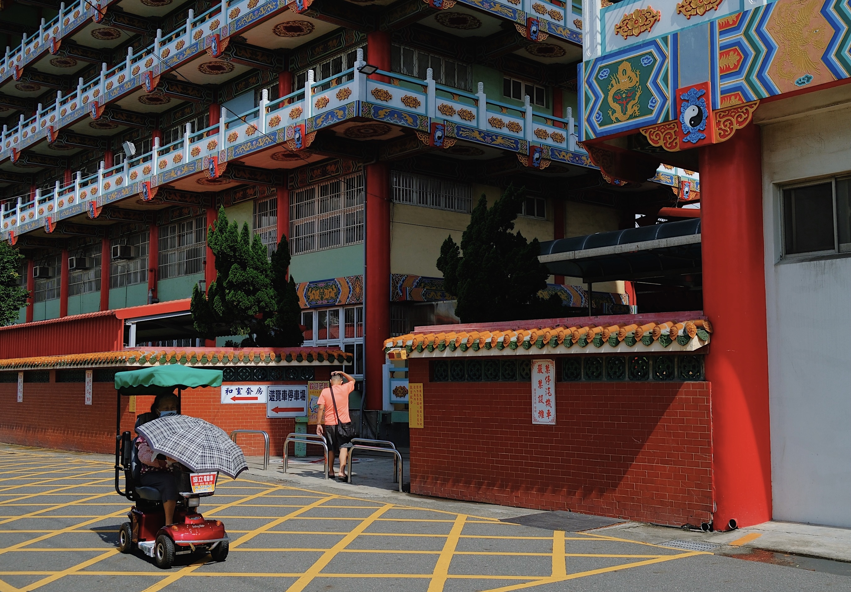 A richly decorated Taoist temple in Tainan, Taiwan, featuring a red pagoda with intricate roof carvings and painted mythological motifs.
