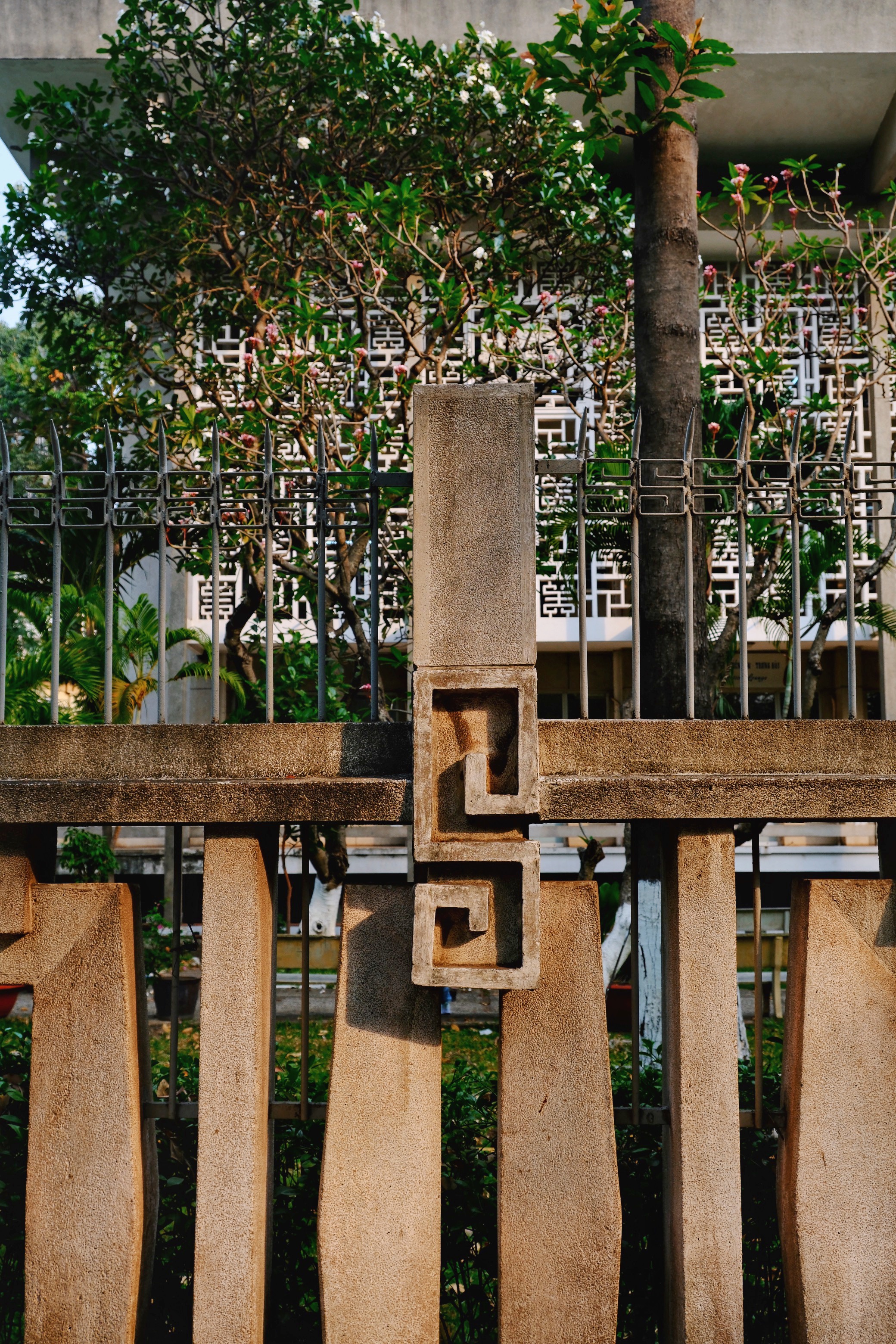 Ornamental concrete gate at the General Sciences Library, illustrating the fusion of decorative brutalism and tropical modernist landscaping.
