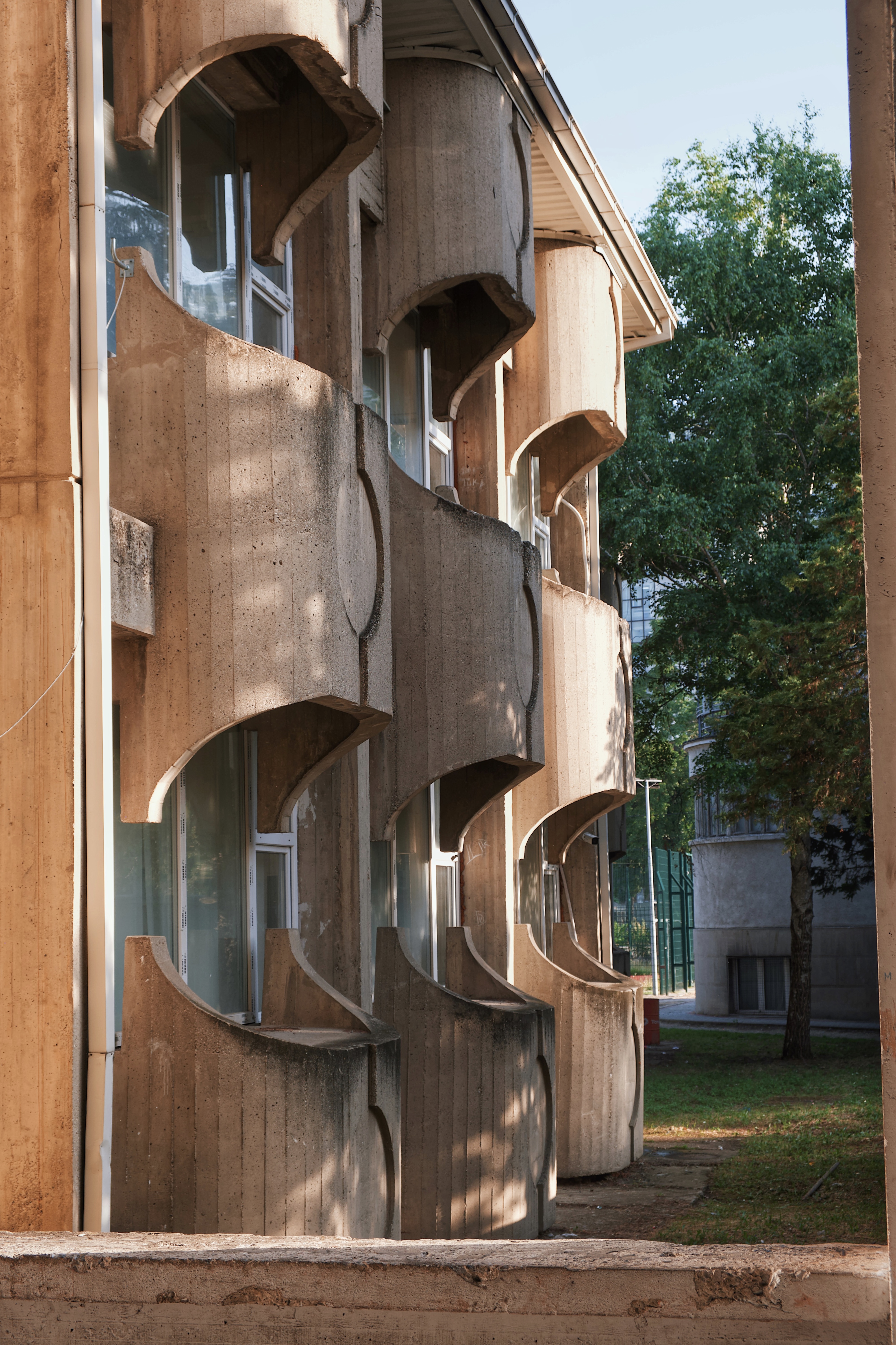Brutalist facade of the Faculty of Medicine in Skopje, featuring curved concrete forms and modernist design elements