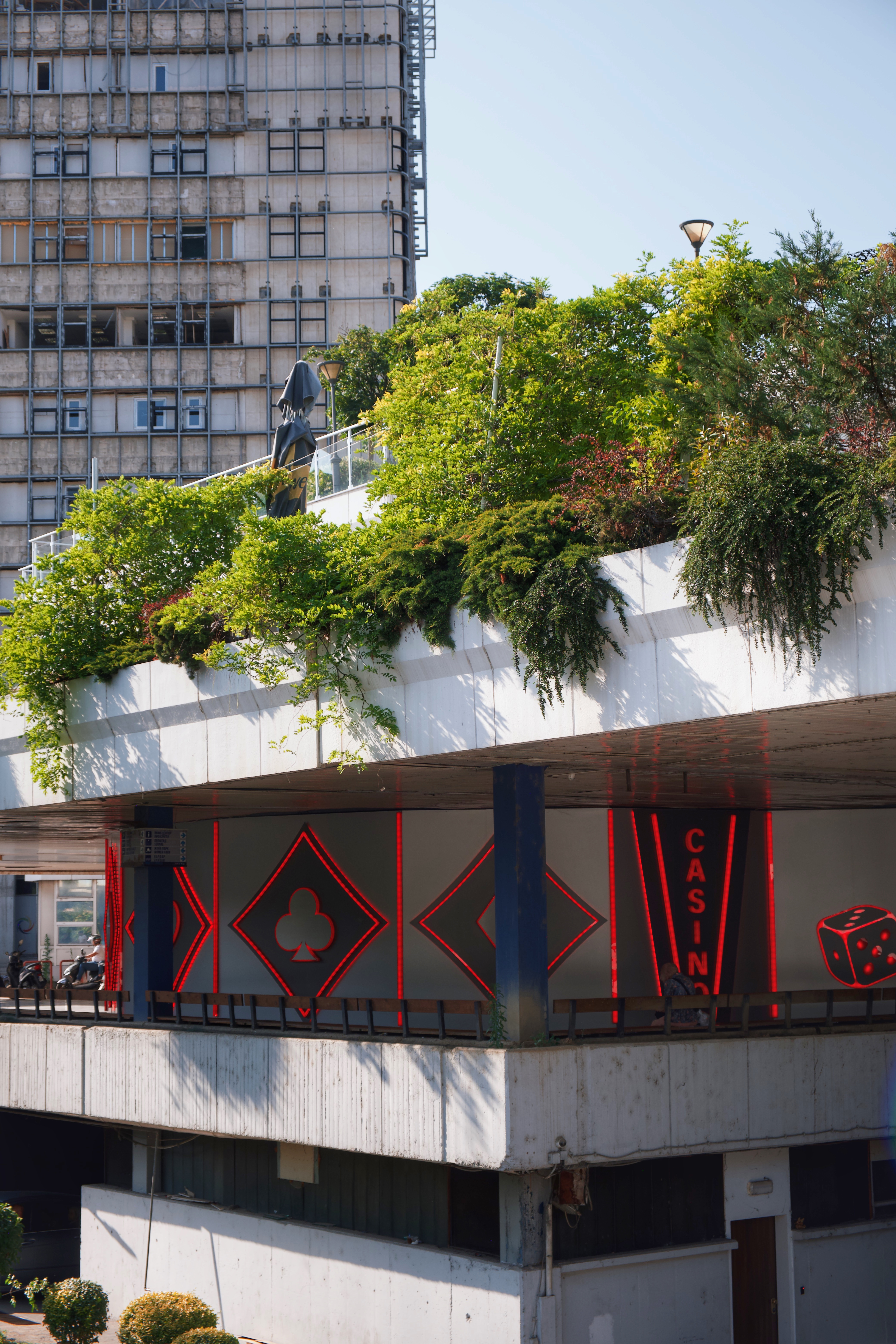 Rooftop greenery and neon signage at the City Trade Center in Skopje, a key example of socialist-era modernist commercial architecture